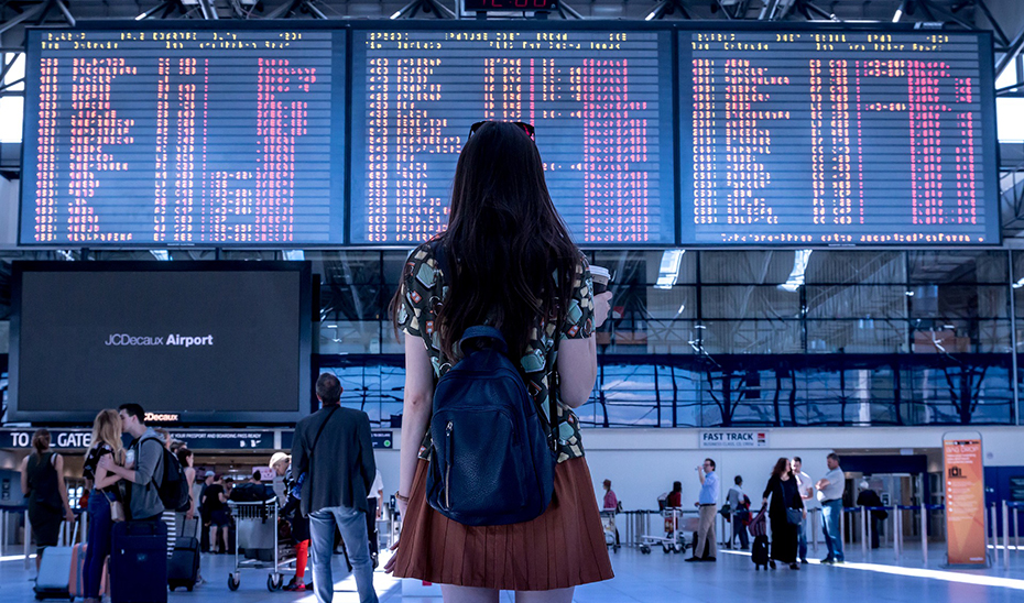 Una mujer observa las pantallas con los vuelos de un aeropuerto.