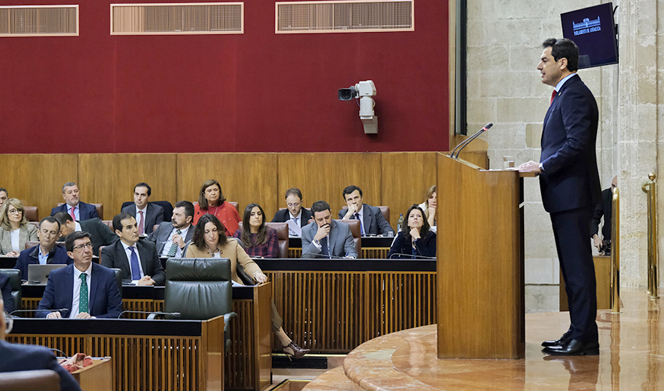 Juanma Moreno se dirige a los diputados del Parlamento de Andalucía desde el atril.