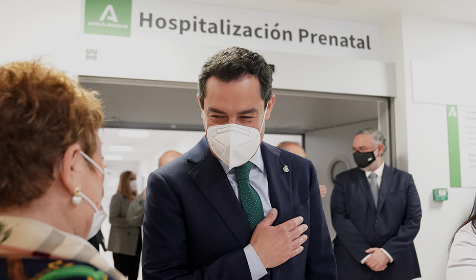 El presidente Juanma Moreno conversa con algunos ciudadanos durante su visita al hospital.