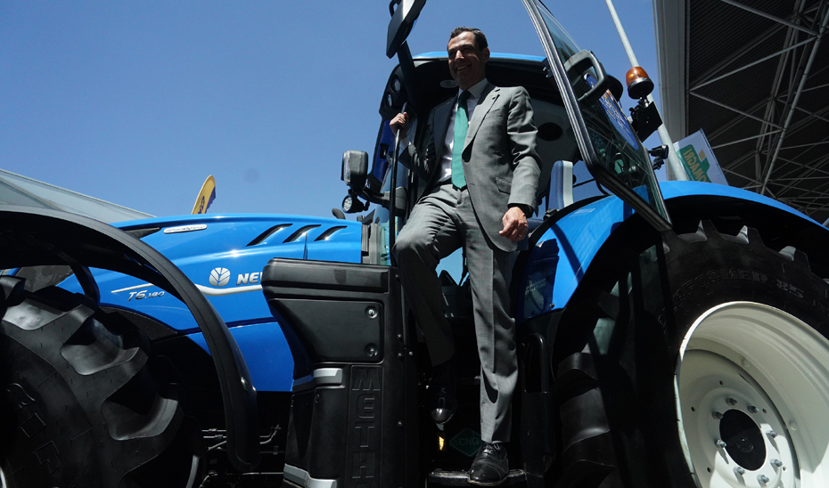Juanma Moreno, en un tractor expuesto en la sección de maquinaria agrícola de Expoliva.
