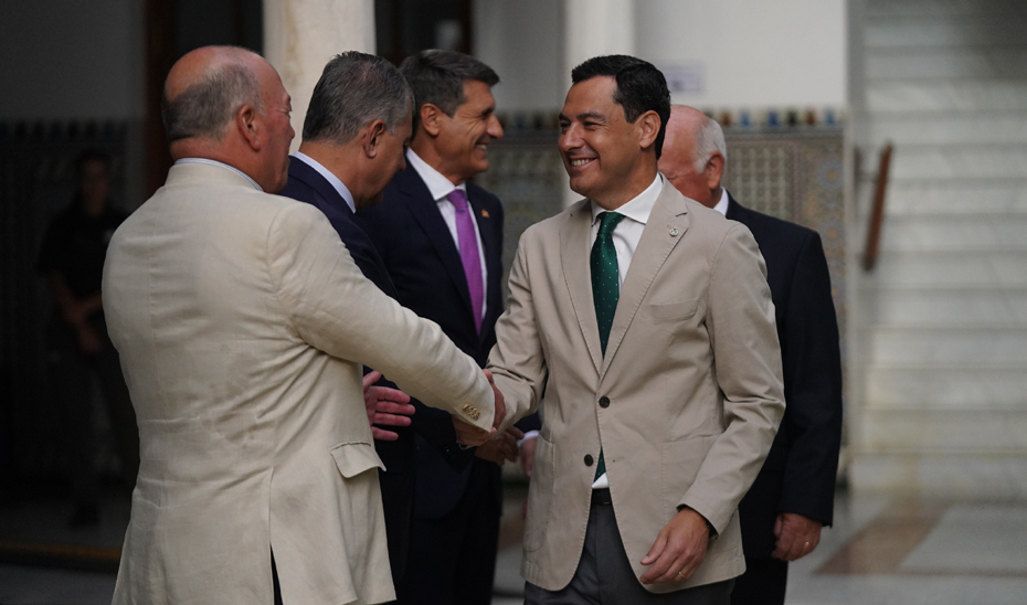 Juanma Moreno saluda al vicepresidente de la Fundación Blas Infante, Javier Delmás Infante.