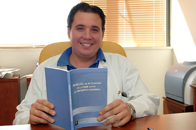 El doctor Ochoa muestra el manual que él ha coordinado