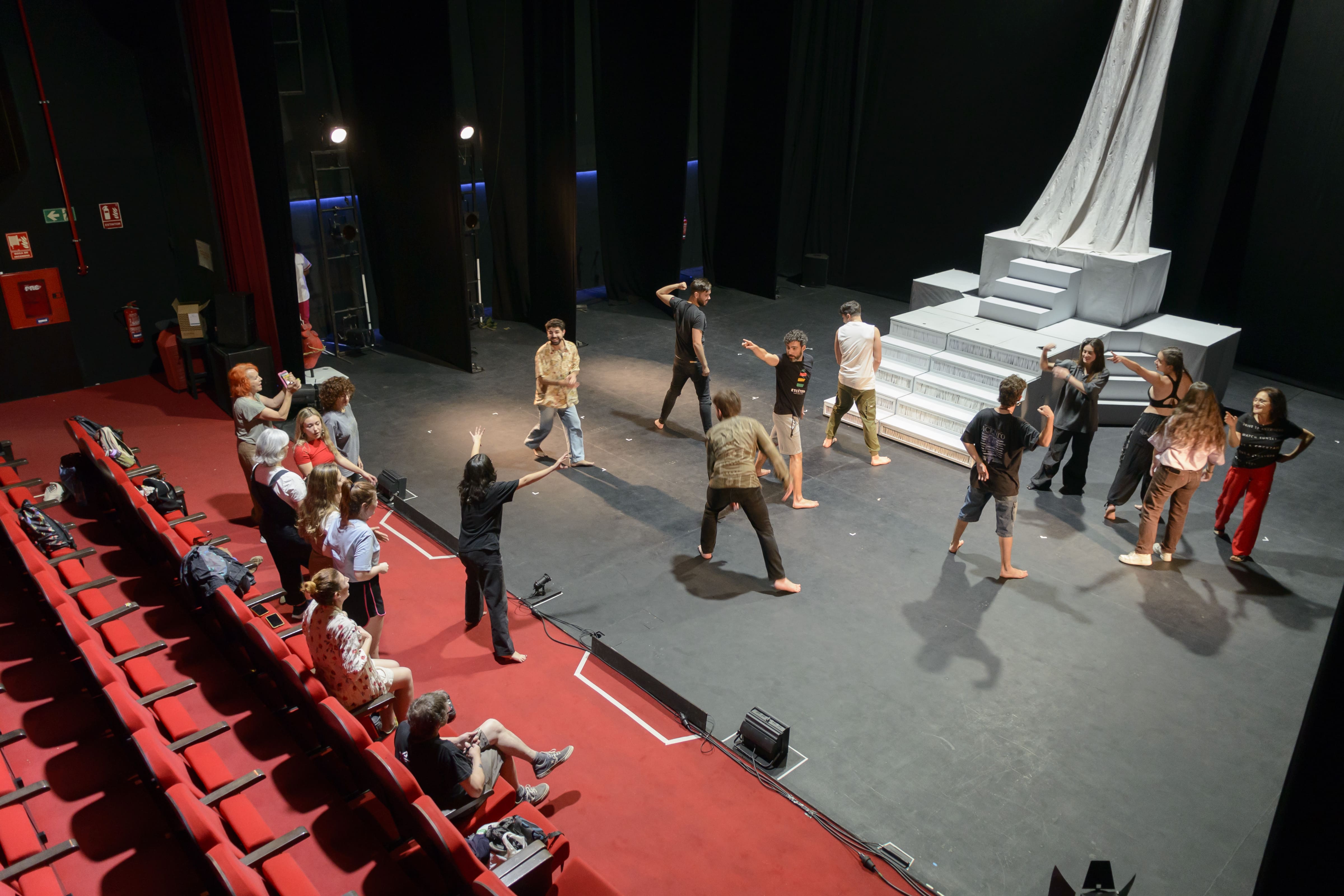 Plano general, y desde arriba, del patio de butacas y del escenario del teatro Alhambra con calentamiento de actores, personal de dirección y técnico antes de dar comienzo un ensayo