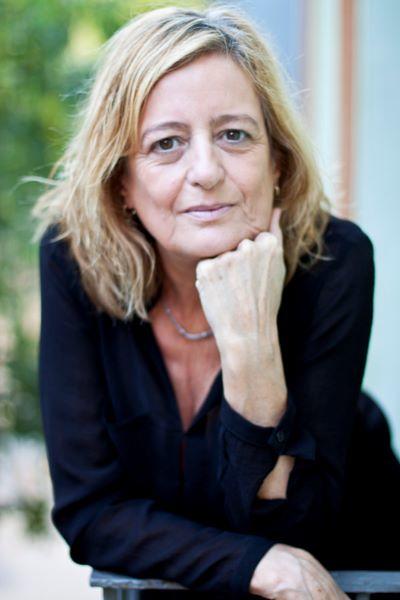 Mujer rubia con vestido negro apoyada en una baranda. Retrato exterior. Plano medio 