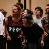 Medio plano de cuatro mujeres y dos hombres ensayando una propuesta con la nariz roja de payaso.