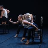 Tres bailarinas en escena con sillas negras de nea gritando al viento.