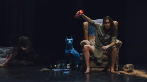 Mujer sentada en sillón con postura defensiva con dinamita en las manos Teatro Cánovas.