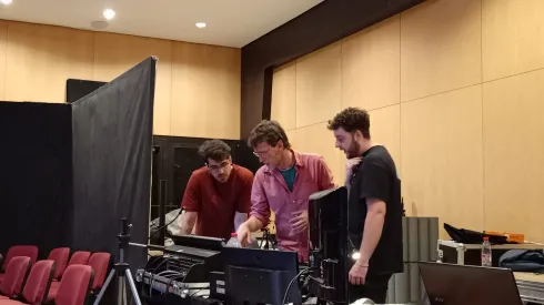 El titular del área de sonido, Morrison, flanqueado por dos alumnos explica el uso de una mesa en el plató del Rey Chico