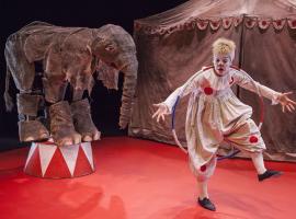 Elefante con el payaso y una carpa del circo al fondo