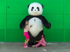 Oso panda con dos bailarinas abrazando al oso