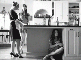 tres mujeres en la cocina, una de ellas debajo de la mesa