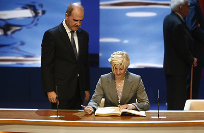 El presidente andaluz, Manuel Chaves, observa como la deportista Carmen Herrera estampa su firma en el Libro de Honor de la Junta.