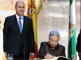 La sevillana Adela Domingo firma en el Libro de Honor ante el
          presidente de la Junta de Andalucía, Manuel Chaves, y el diseñador cordobés Elio
          Berhanyer, otro de los galardonados.