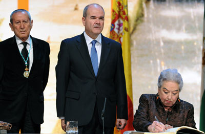La sevillana Adela Domingo firma en el Libro de Honor ante el presidente de la Junta de Andalucía, Manuel Chaves, y el diseñador cordobés Elio Berhanyer, otro de los galardonados.