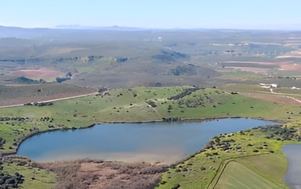 Vista aerea de la Laguna de Tíscar, al fondo un paisaje de olivar, viñedos y cereal de la campiña cordobesa.