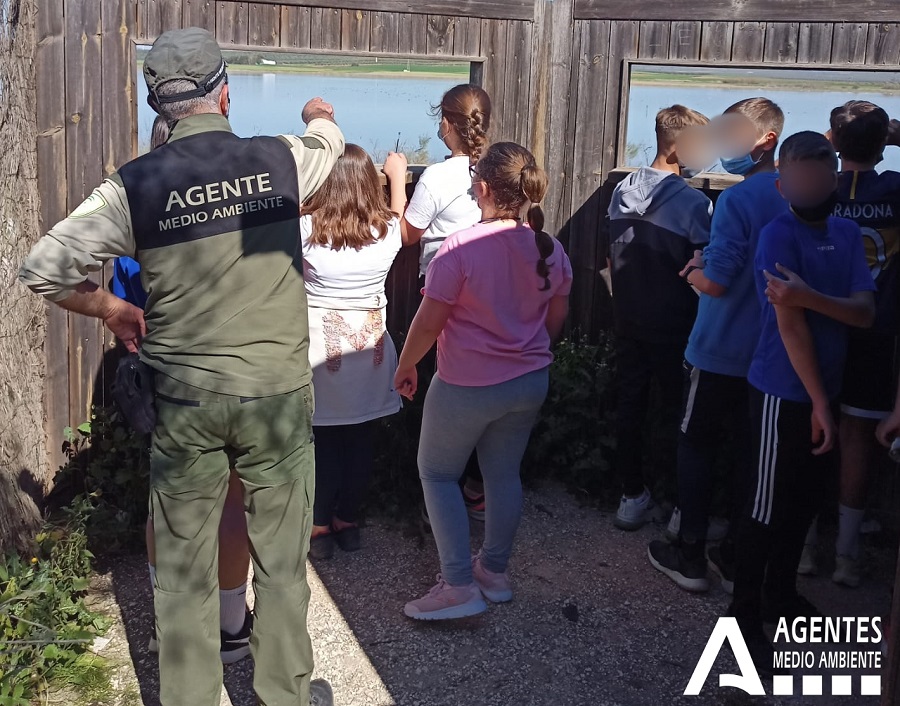 Ampliar imagen: Agente de Medio Ambiente realizando una actividad educativa con un grupo de escolares al aire libre