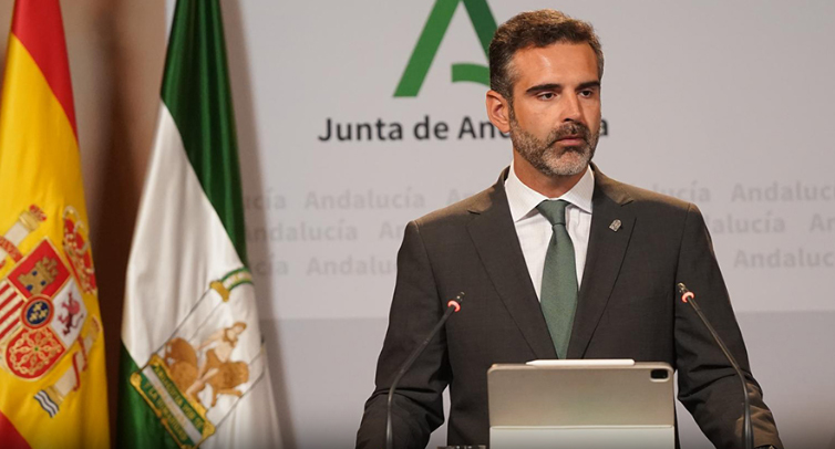 Ampliar imagen: Ramón Fernández-Pacheco en el atril, junto a las banderas de España y Andalucía, contestando a los medios de comunicación