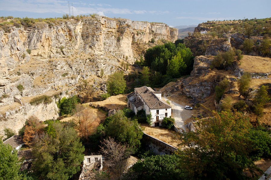 Ampliar imagen: cañón de gran altura con árboles al fondo del mismo, con construcciones típicas andaluzas en uno de sus lados