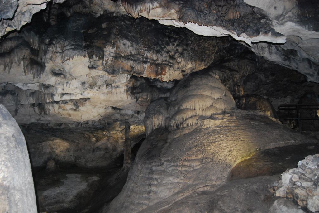 Ampliar imagen: fotografía de una gran cueva con algunas estalactitas y una gran columna natural en lado derecho de la imagen