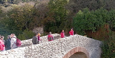 Personas cruzando por un puente antiguo, de piedra