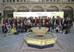 Numeroso grupo de asistentes al el evento de presentación, junto a la fuente del patio de una casa/palacio renacentista