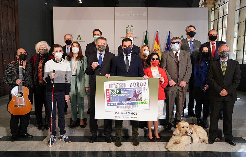 El presidente Juanma Moreno, con los participantes en el acto de presentación del Cupón con motivo del 28F.