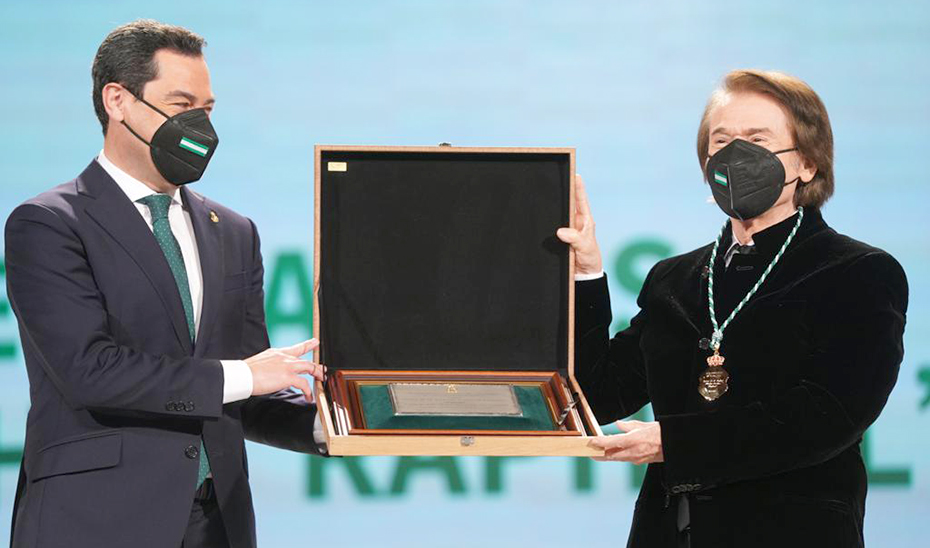 Raphael recoge de manos del presidente de la Junta de Andalucía, Juanma Moreno, la placa que lo reconoce como Hijo Predilecto de Andalucía.