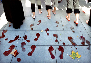 Pisadas en condena a un episodio de violencia de género. (Fotos EFE)