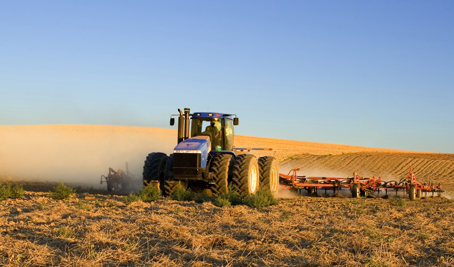 
			      Un tractor durante el proceso de arado de unas tierras.			    
			  