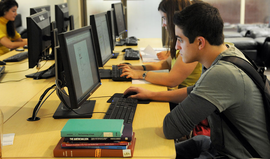 
			      Estudiantes realizan trámites en sus ordenadores.			    
			  