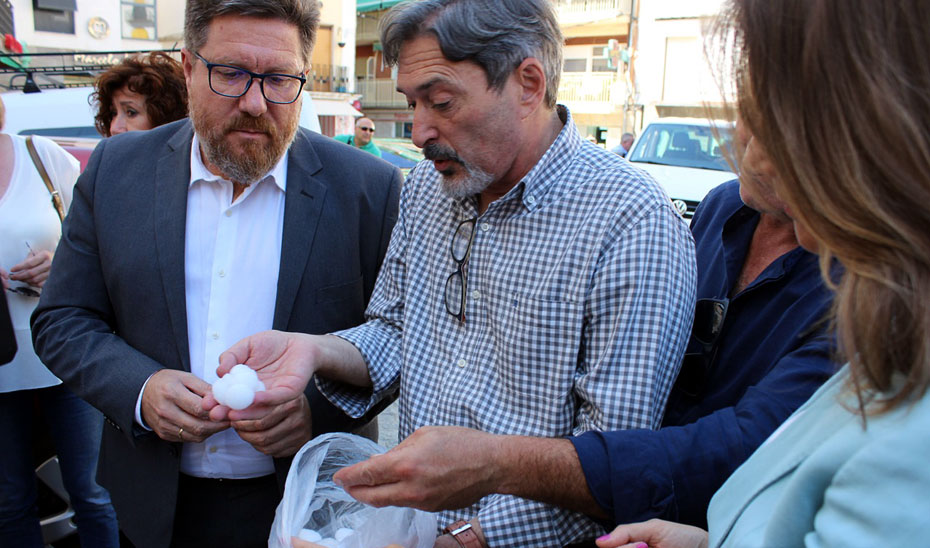 El alcalde de Alcaudete muestra a Sánchez Haro las dimensiones alcanzadas por el granizo caído.