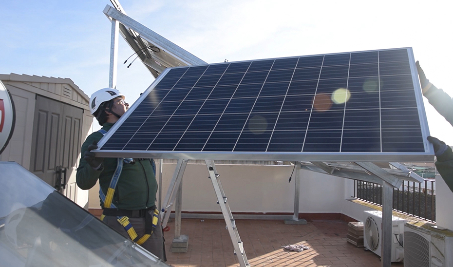 Operarios instalan placas solares para autoconsumo doméstico.