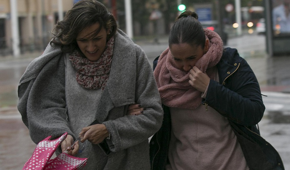 Dos mujeres se protegen del viento (Europa Press).