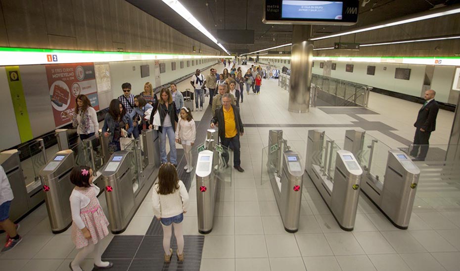 Usuarios del metro de Málaga pasando por el control de salida en una de las estaciones.