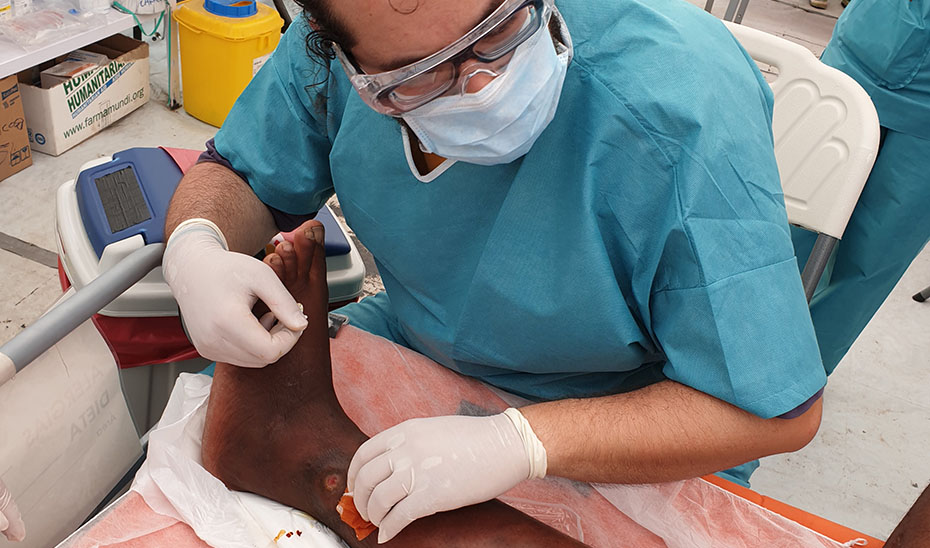 Un sanitario andaluz cura la pierna de uno de los heridos por el ciclón Itai a su paso por Mozambique.