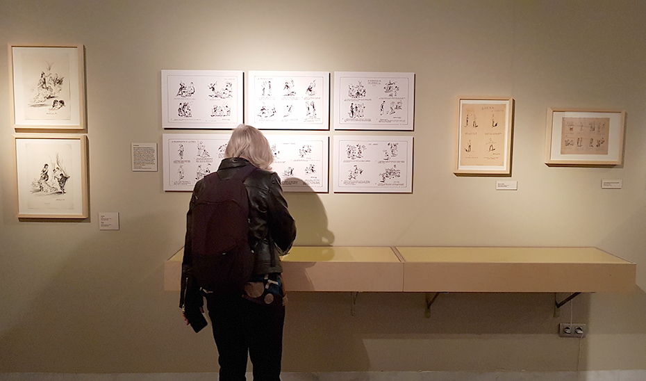 Una mujer observa algunos de los dibujos expuestos de Martínez de León.