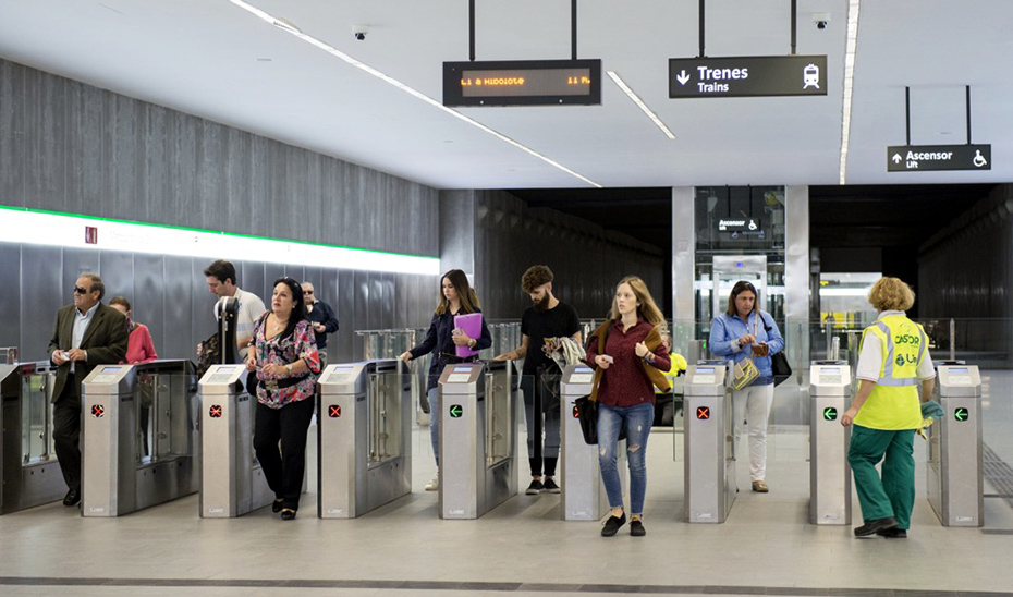 Usuarios del metro de Granada pasando por los tornos de control de acceso.