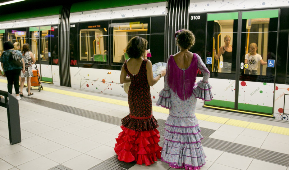 Dos mujeres vestidas de flamenca en el metro de Málaga.