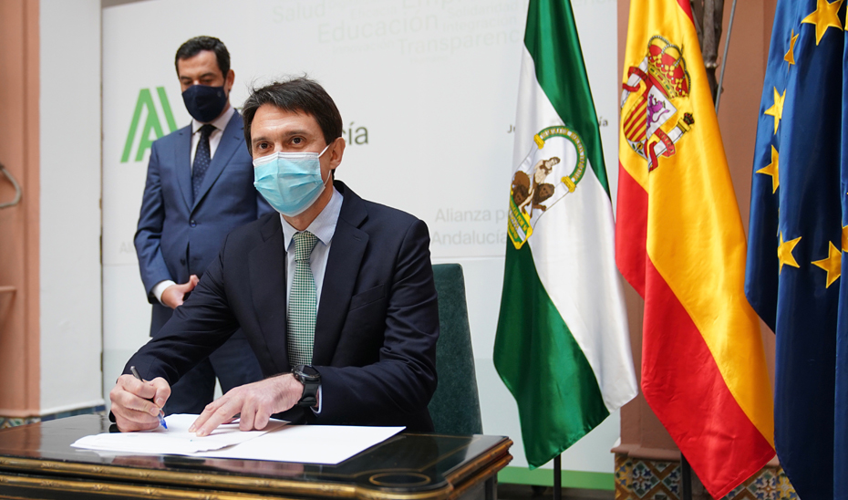 El presidente de los Laboratorios Rovi, Juan López-Belmonte, firma el convenio con la Junta en presencia de Juanma Moreno.