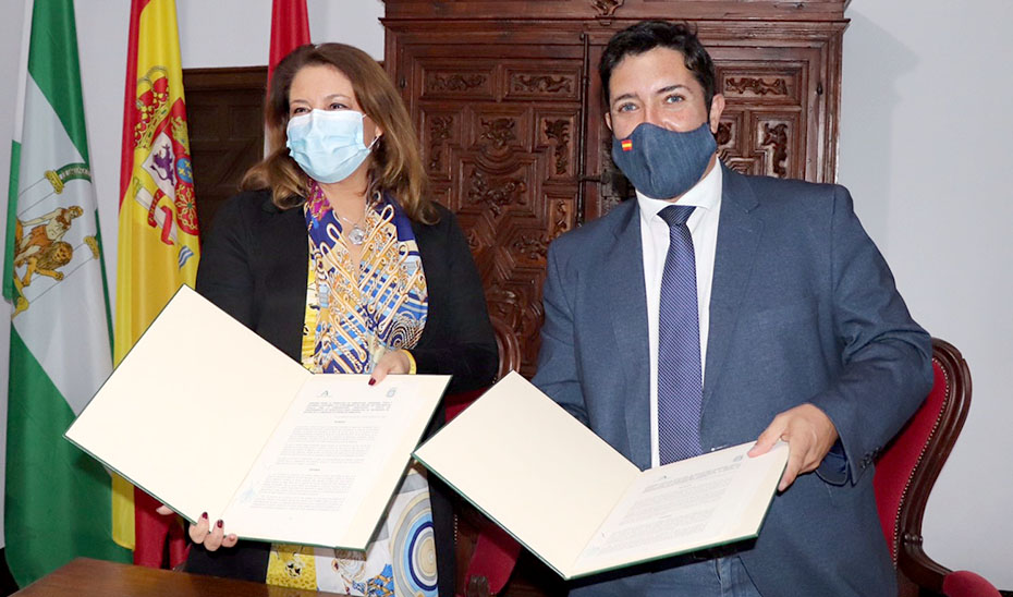 La consejera Carmen Crespo y el alcalde de Lora del Río muestran el convenio firmado.