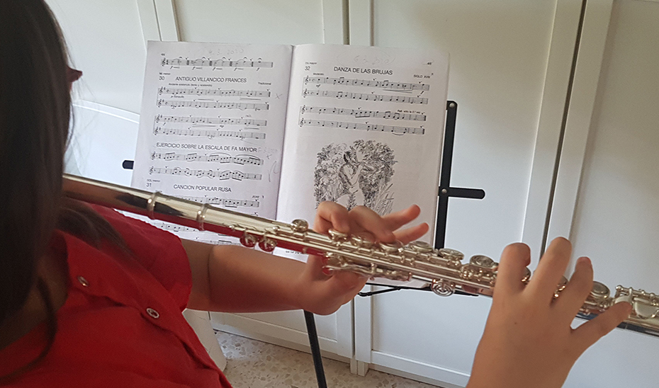 Una joven alumna de conservatorio estudiando flauta.