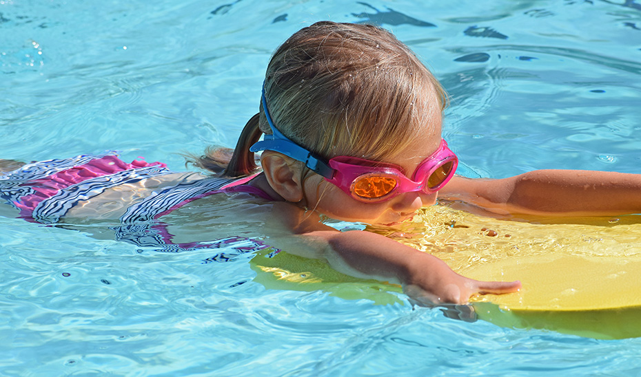 Una niña juega en una piscina.