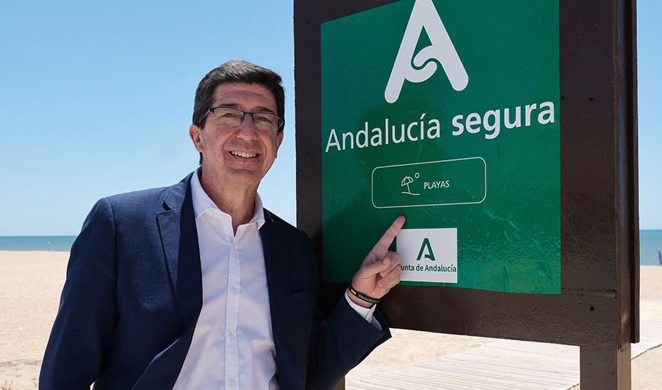 El vicepresidente de la Junta y consejero de Turismo, Juan Marín, junto a un cartel de Andalucía Segura para las playas.