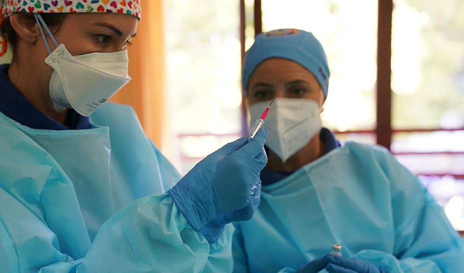 Dos enfermeras preparan la vacuna para su administración.