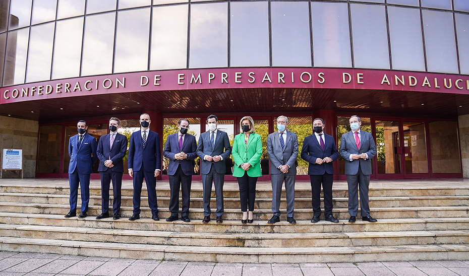 El presidente andaluz, Juanma Moreno, a su llegada a la sede de la CEA, con los representantes de los empresarios.