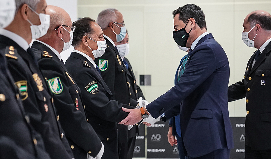 El presidente de la Junta saluda a miembros del Cuerpo Nacional de Policía Adscrita a la Junta a su llegada al acto.