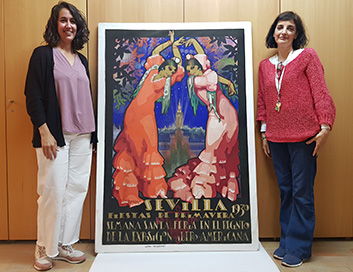 Las conservadoras del Museo de Artes y Costumbres Populares de Sevilla María Venegas (izquierda) y Elena Hernández (derecha), junto a uno los carteles almacenados en el recinto expositivo.