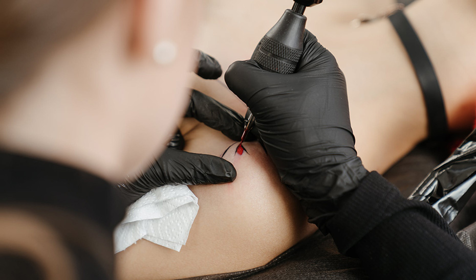 Un profesional realiza un tatuaje sobre la piel de un cliente.