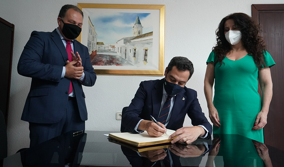 El presidente firma en el libro de autoridades junto al alcalde y la consejera de Igualdad.