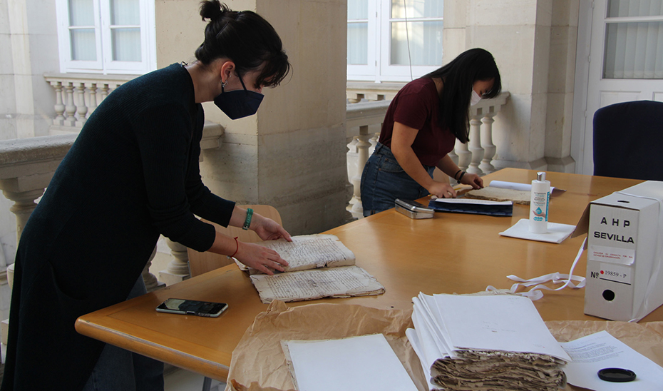 Trabajadoras del Archivo Histórico Provincial de Sevilla con algunos documentos muy antiguos.